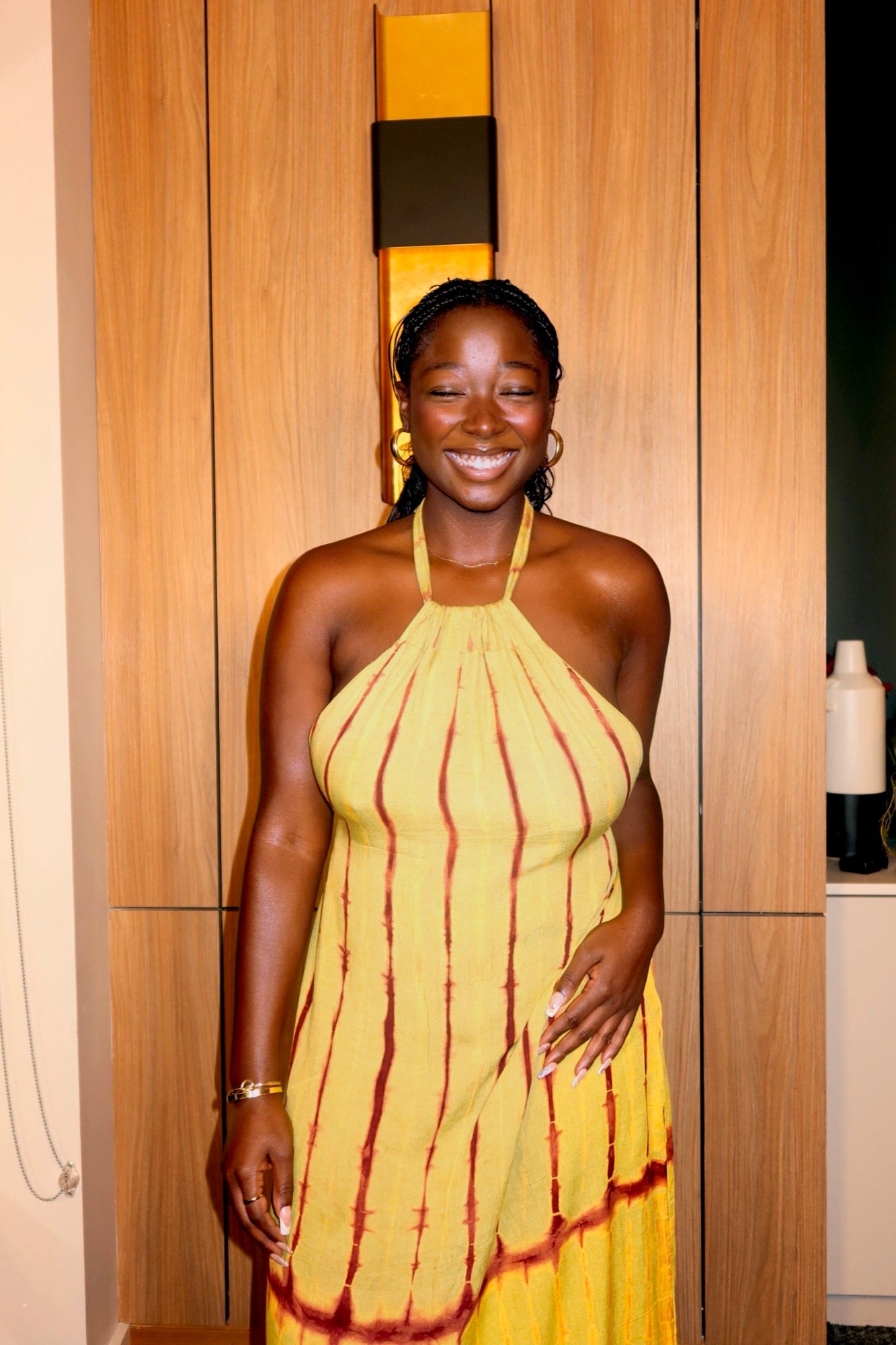 Model smiling in the Belle de Dos dress in Citron and Burgundy, chartreuse with burgundy tie-dye stripes
